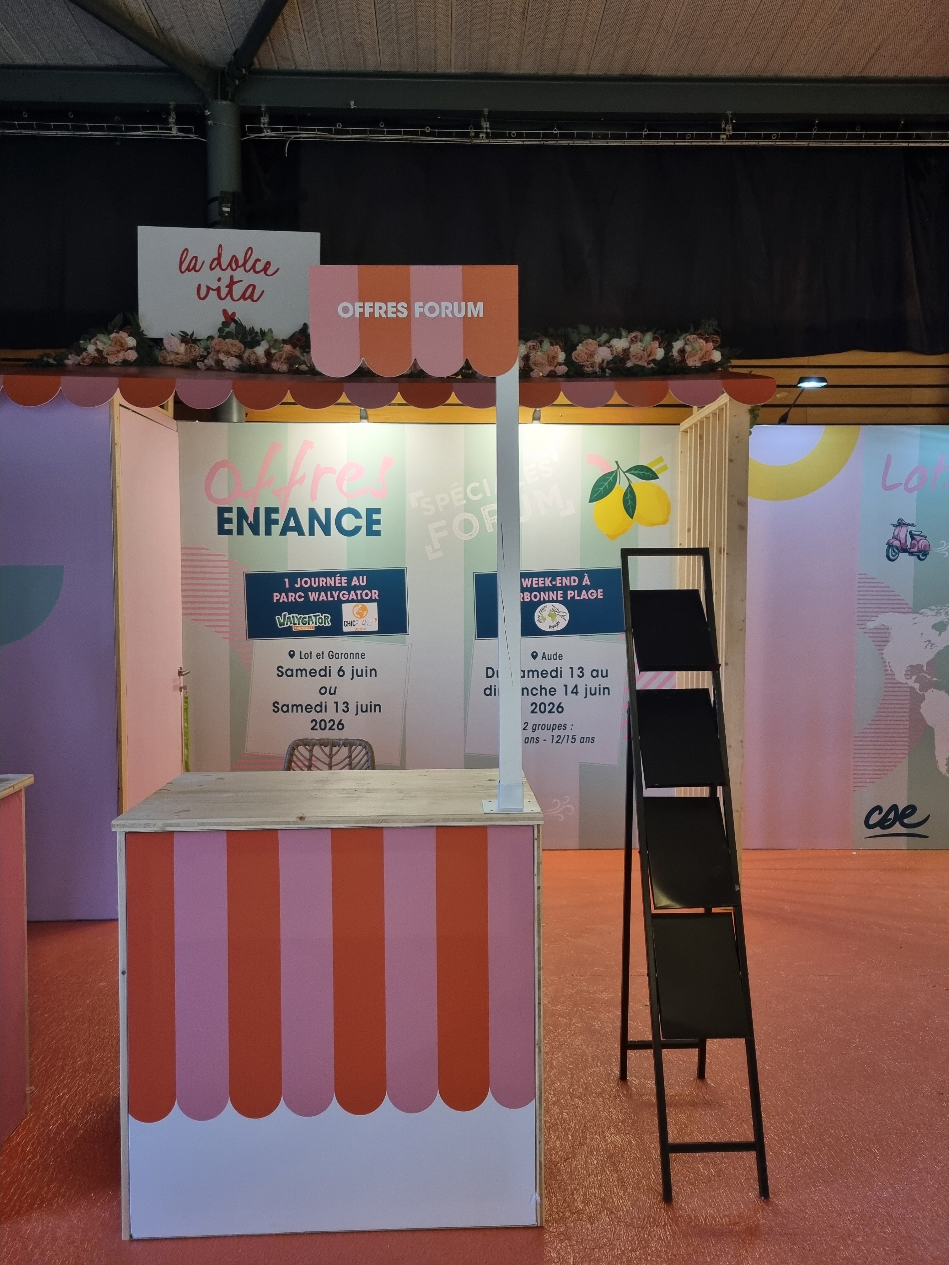 Comptoir de stand rayé rose et orange sous enseigne salon