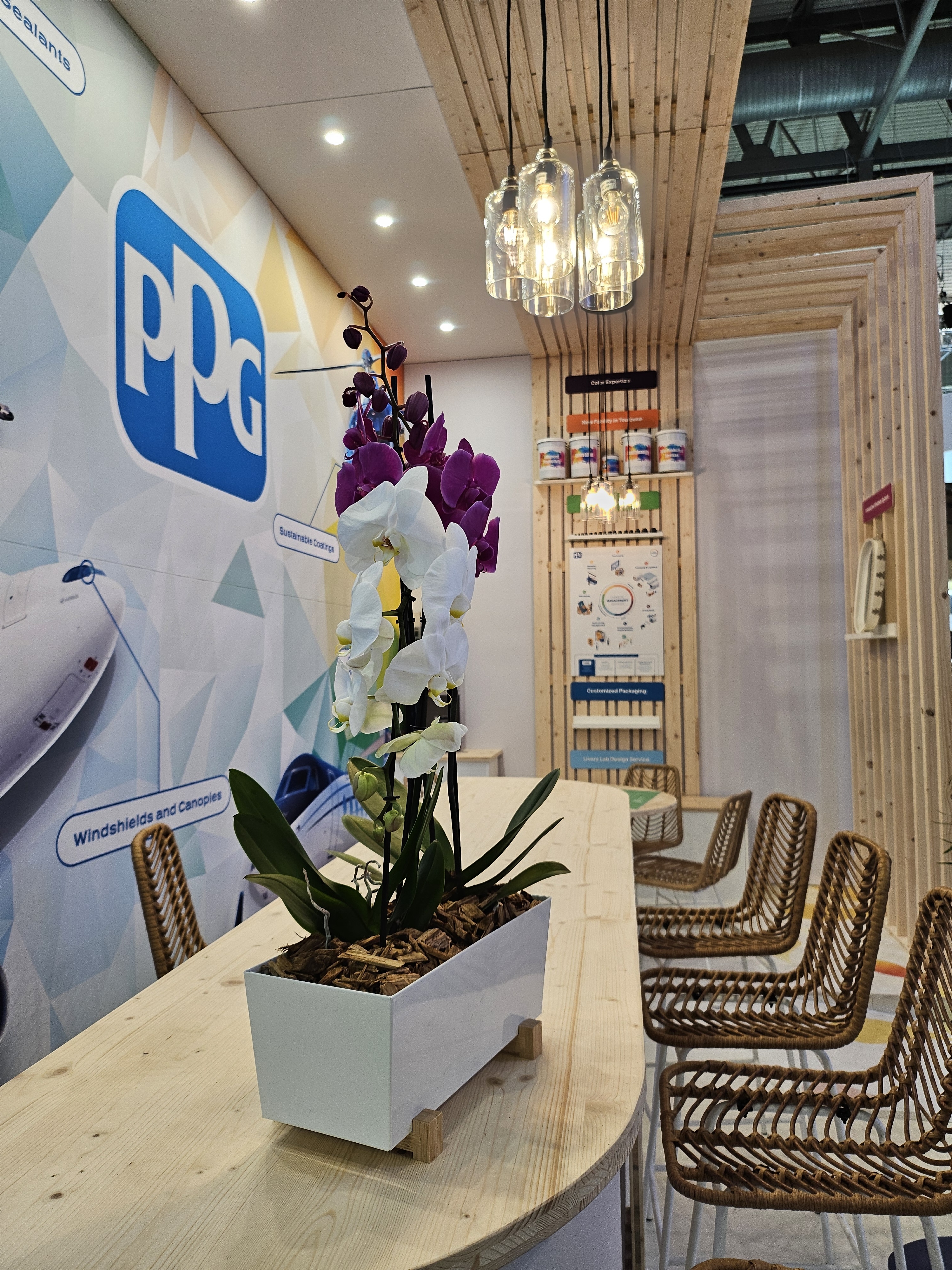 Bar d'accueil en bois avec chaises hautes en osier pour PPG
