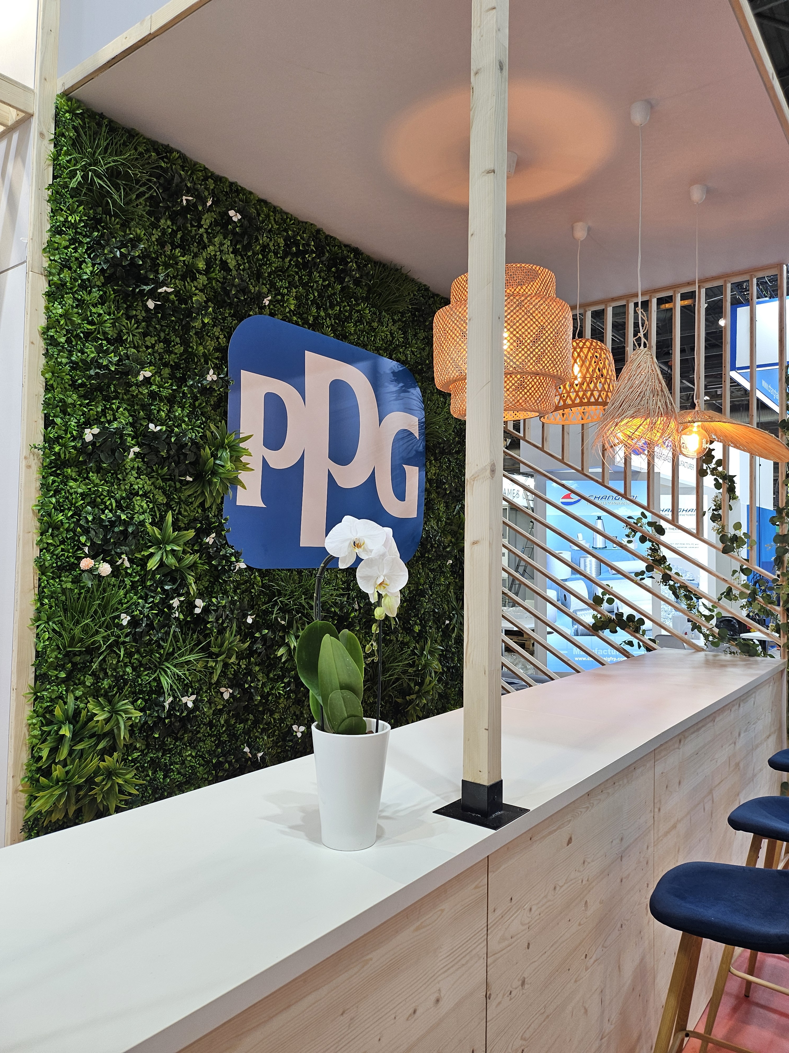 Bar d'accueil avec mur végétal et le logo de PPG